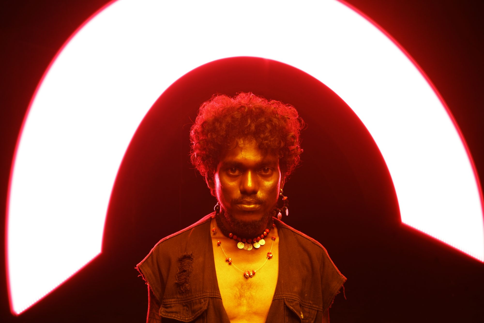 man with ring light arc red, creative studio